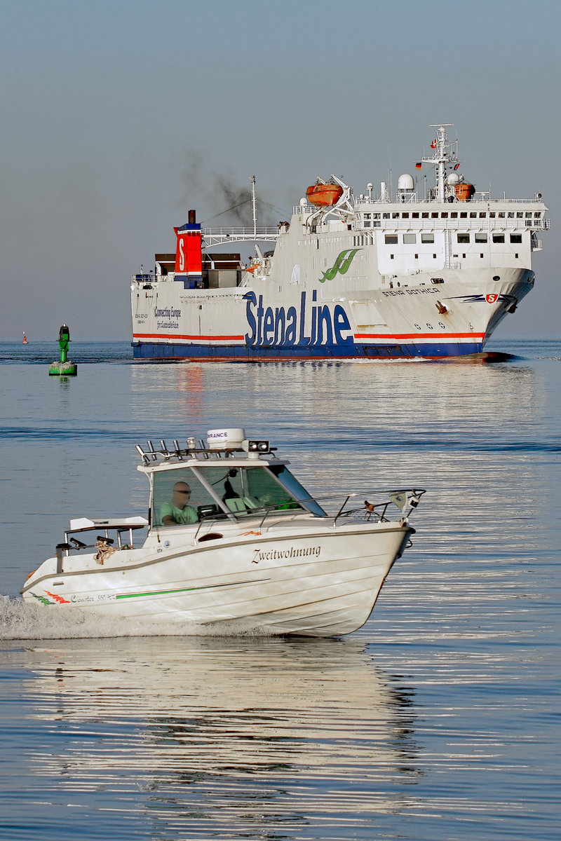 Motorboot ZWEITWOHNUNG läuft vor dem Fährschiff STENA GOTHICA am Abend des 12.10.2018 in den Hafen von Lübeck-Travemünde