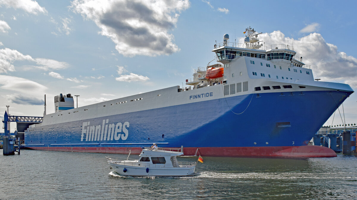 Motorboot ZWERGL fährt an der Finnlines-Fähre FINNTIDE (IMO 9468920) vorbei. Lübeck-Travemünde, 21.08.2021