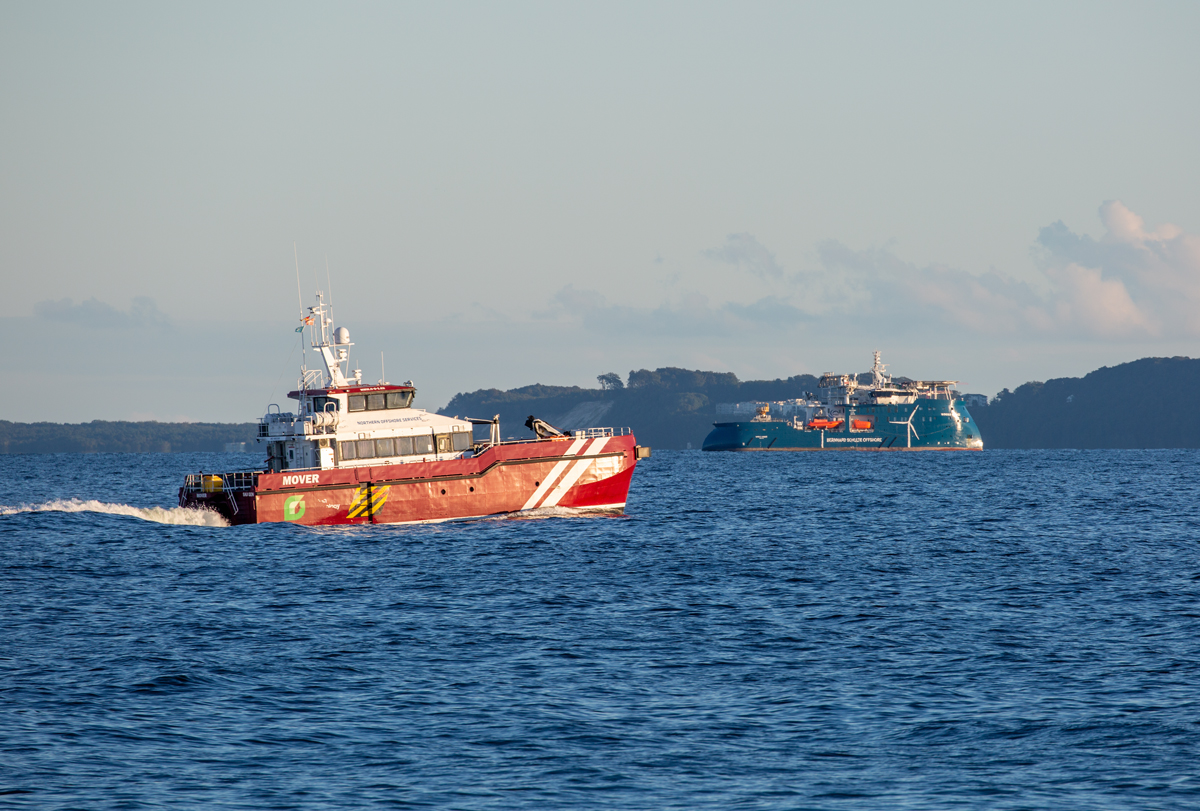 MOVER im abendlichen Licht auf der Fahrt nach Mukran, fährt vorbei an WINDEA LEIBNIZ (IMO 9769037) die z.Z. auf Reede lag. - 01.09.2022