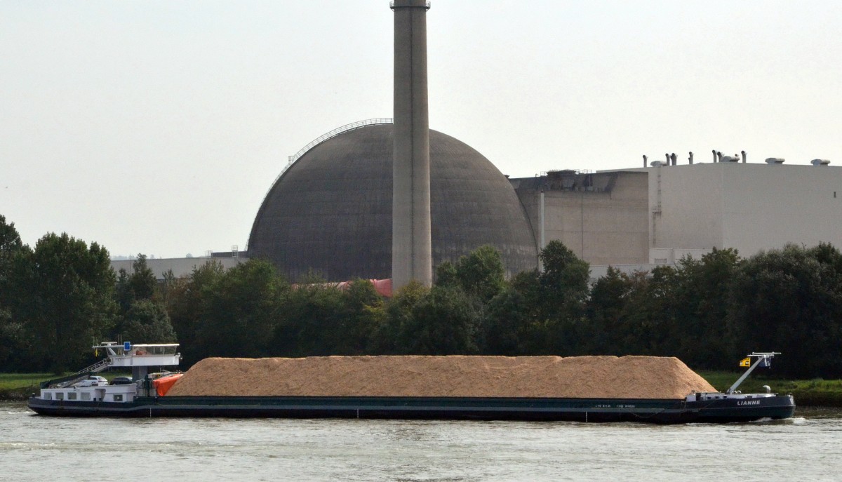 MS Lianne, ein Binnenschiffer, beladen vermutlich mit Holzspnen auf dem Rhein bei  Neuwied am 24.09.2013. Im Hintergrund das stillgelegte AKW Mhlheim Krlich .