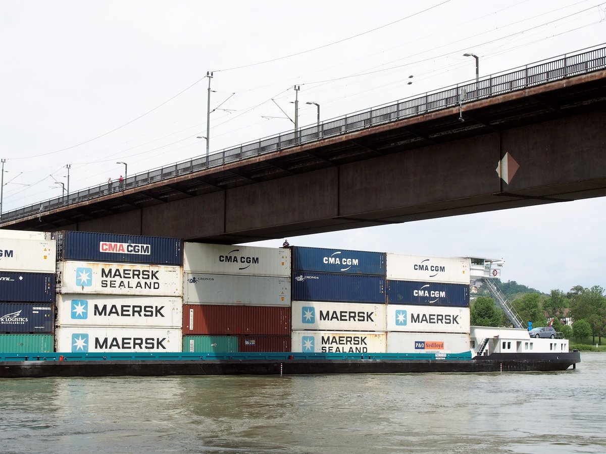 Nachdem sich der Koppelverband unter der Brücke festgefahren hatte, muss der Bahnverkehr eingestellt und der Schiffsverkehr eingeschränkt werden. Hier beobachtet ein auf den Containern stehendes Besatzungsmitglied, ob sich der Abstand zwischen Ladung und Brücke verändert. (20. Mai 2016)