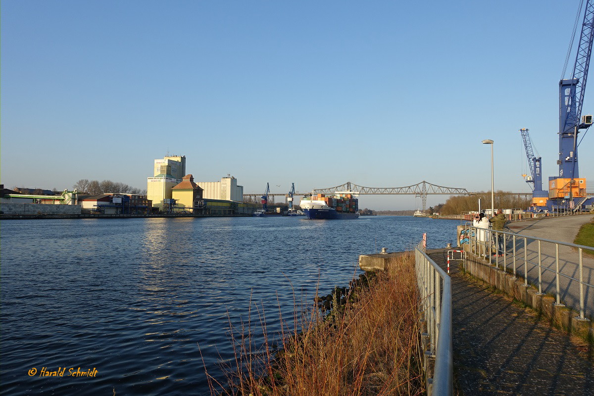 Nord Ostsee Kanal am 10.4.2023 Höhe Hafen Rendsburg mit einem Teil der Eisenbahnhochbrücke und dem aufkommenden Feederschiff  BERNHARD SCHEPERS Richtung Brunsbüttel fahrend  /