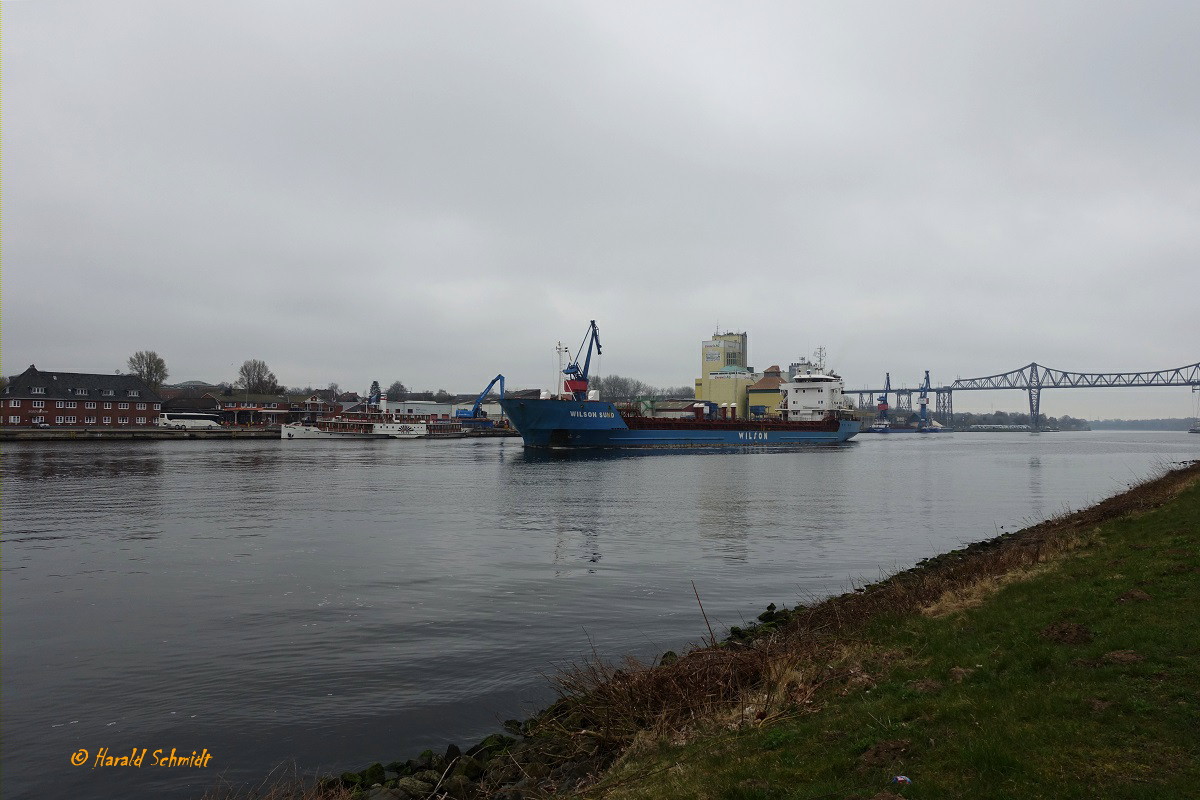 Nord Ostsee Kanal am 9.4.2023 Höhe Hafen Rendsburg mit einem Teil der Eisenbahnhochbrücke und dem aufkommenden Mehrzweckfrachter  WILSON SUND Richtung Brunsbüttel fahrend  /