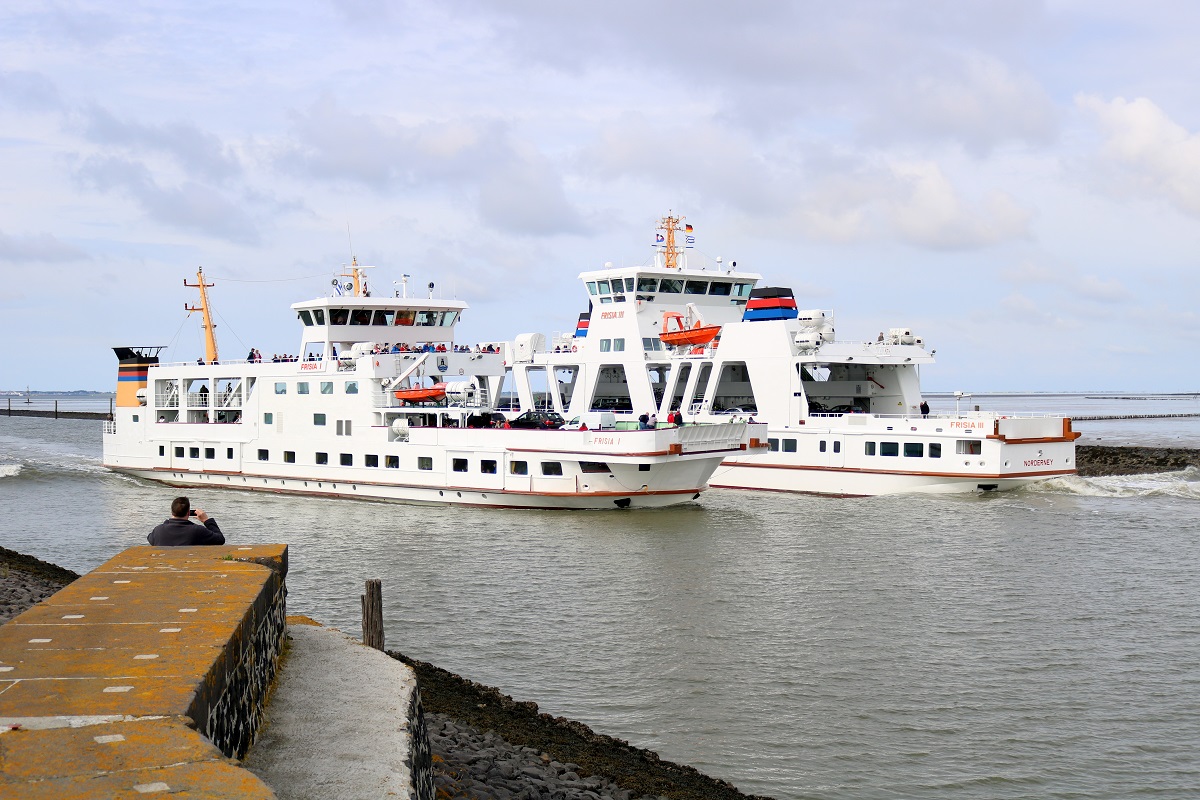 Personenfähre  Frisia I  (Bauj. 1970) (l.) nach Norddeich neben  Frisia III  (Bauj. 2015), das neue Flaggschiff der Reederei Norden-Frisia, nach Norderney. Aufgenommen am Hafen Norddeich. [24.7.2017 - 17:05 Uhr]