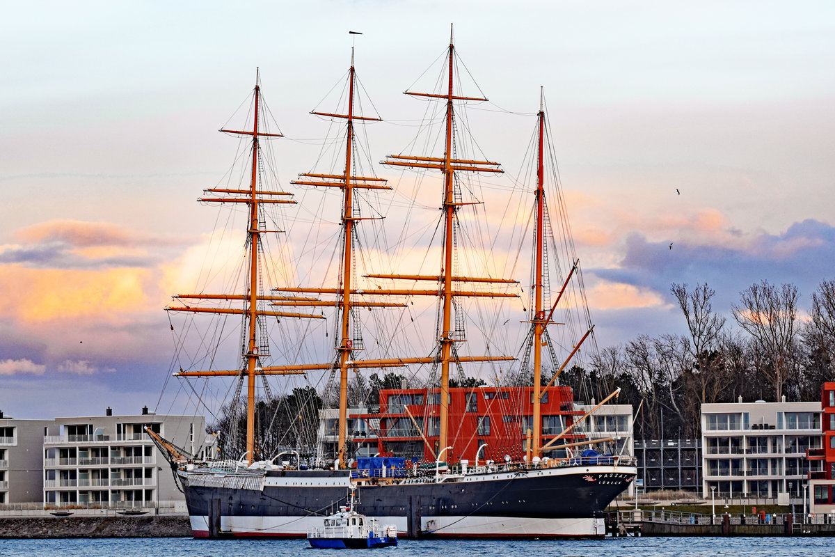 Polizeiboot HABICHT fährt im Licht der untergehenden Sonne an der Viermastbark PASSAT vorbei. Lübeck-Travemünde, 14.03.2021