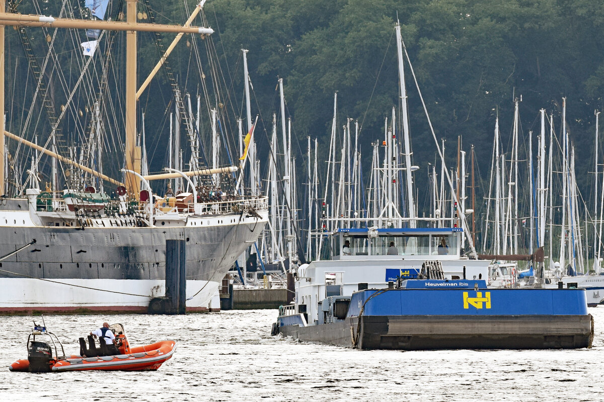 Polizeiboot HOOGE beim Bagger- und Arbeitsschiff IBIS VI am 13.08.2021 in Lübeck-Travemünde.

Wenige Minuten zuvor war über Lautsprecher, die an der Spitze der Nordermole und beim Lotsenhaus-Turm angebracht sind, IBIS VI  öffentlich  in deutscher und englischer Sprache aufgefordert worden, sich sofort bei  Trave Traffic  über Funk zu melden. Da dies anscheinend nicht geschah, wurde das zu sehende Polizeiboot HOOGE geschickt. Mit eingeschaltetem Blaulicht geleitete es IBIS VI, das nun die Maschinen rückwärts laufen ließ, an den Ostpreussenkai Travemünde.  