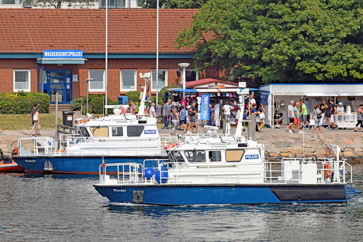 Polizeiboot WARDER fährt an der Travemünder Wasserschutzpolizei-Station mit dem davor liegenden Polizeiboot HABICHT vorbei. Aufnahme vom 22.7.2018