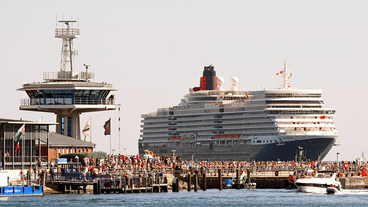 QUEEN ELIZABETH am 7.8.2018 in Lübeck-Travemünde einlaufend. Sehr viele Menschen sind hierher - auch zur Nordermole, wie im Bild zu sehen - gekommen, um  Ihre königliche Majestät  zu begrüßen.  