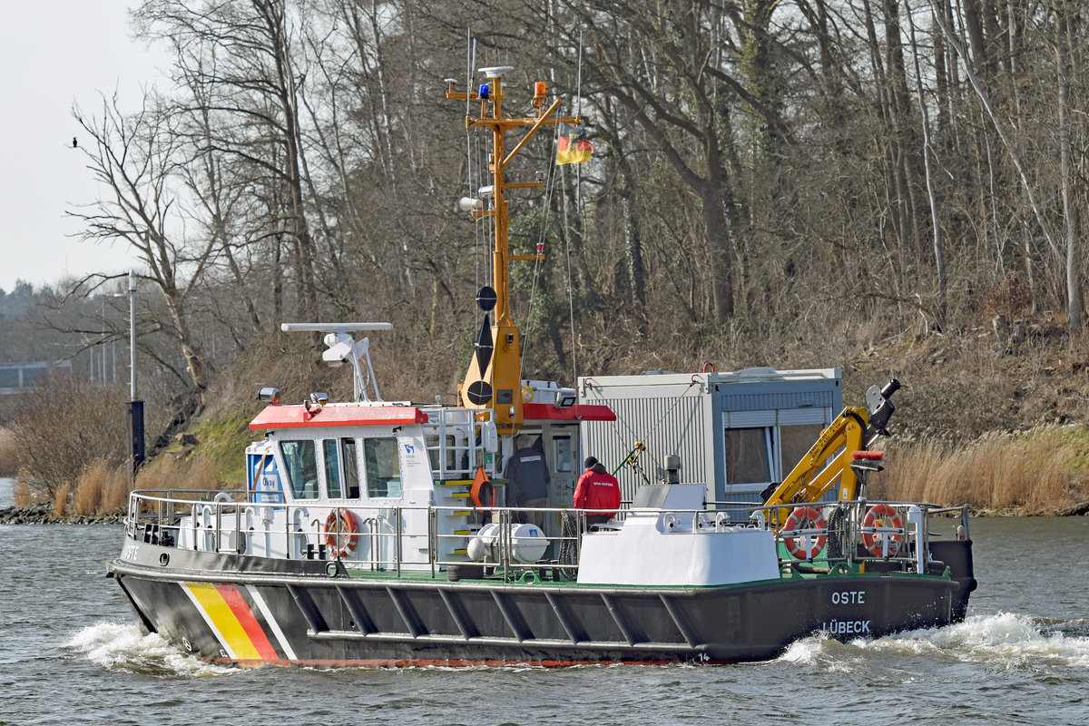 Schifffahrtspolizeiboot OSTE am 25.02.2021 auf der Trave bei Lübeck. Es hat den Deckprahm 1043 längsseits im Schlepp