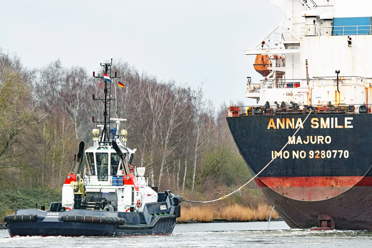 Schlepper ARGUS (IMO 9600762) am 11.12.2021 beim Bulk Carrier ANNA SMILE. Trave bei Lübeck unweit Schellbruch