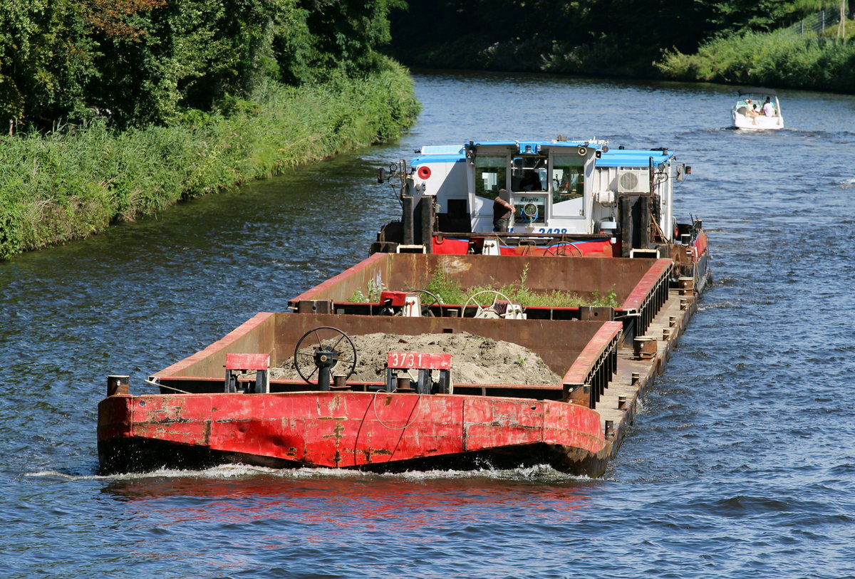 Schubboot SCH 2428 (05603910 , 16,48 x 8,12m) schob am 05.08.2020 zwei beladene Leichter im Teltowkanal Höhe Kleinmachnow zu Tal. Der eine Leichter muß schon länger nicht bewegt worden sein -  Grünzeug  wuchs schon heftig.