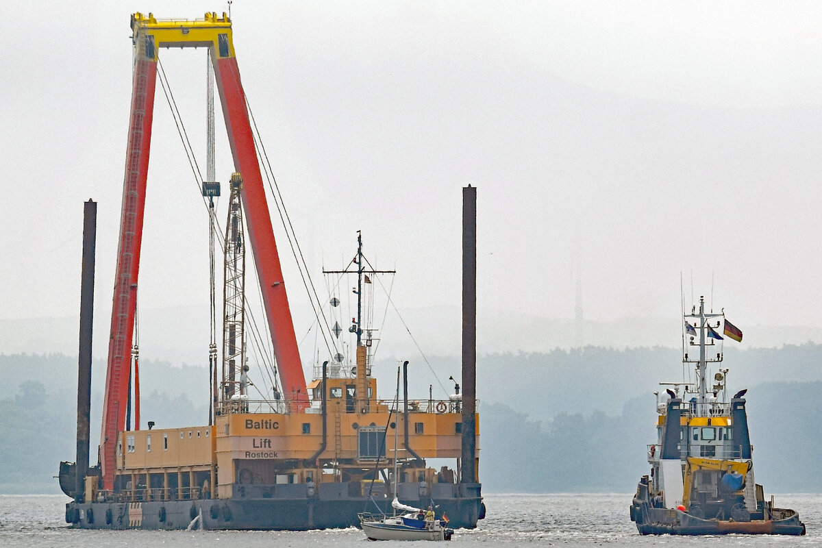 Schwimmkran BALTIC LIFT (IMO 8872796) bringt das Wrack des Kutters DRESDEN von Travemünde nach Lübeck zum dortigen Lehmannkai 4. Achteraus fährt der Schlepper DUTCH PIONEER (IMO 9229544). Aufnahme vom 13.7.2021