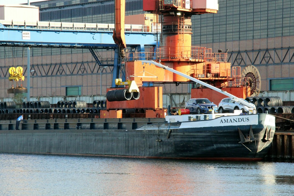 Stahldraht-Rollen werden wie hier zu sehen mittels Kran in Binnenschiffe verladen. GMS  AMANDUS  (02322992) am 24.11.2020 am Elektrostahlwerk Brandenburg/Havel. 