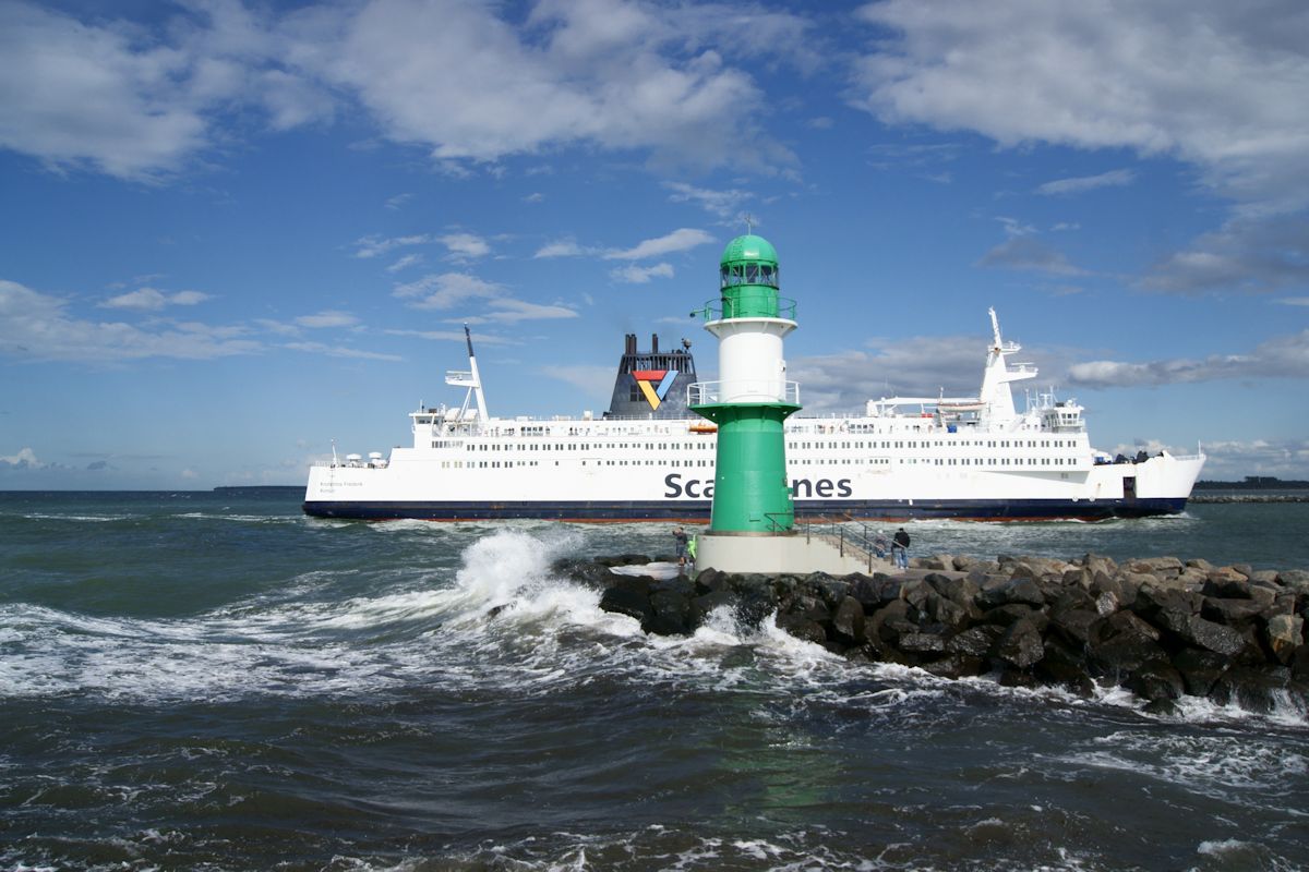 Stürmische See und Sonnenschein herschen an der Westmole von Warnemünde während im Hintergrund die Fähre von Gedser nach Rostock (Kronprins Frederik) vorbeifährt. (10.08.2016)