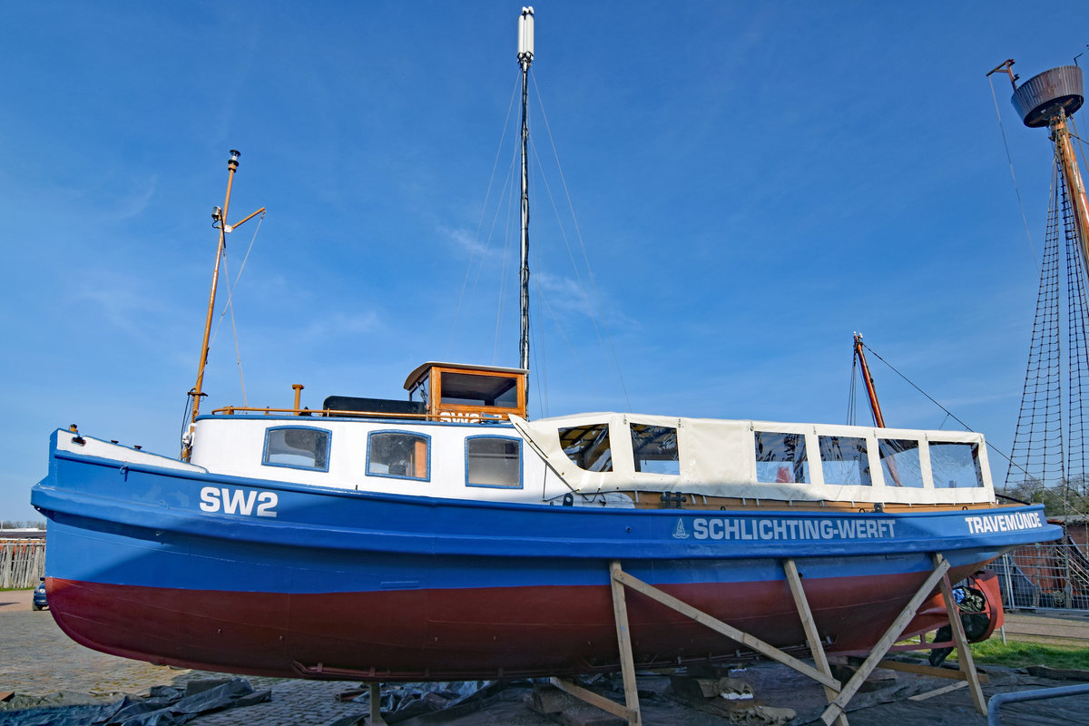 SW2 am 8.4.2020 bei den Media-Docks im Hafengebiet von Lübeck. Die Barkasse wurde auf der Werft J. Oelkers in Hamburg erbaut und unter dem Name „Fritz“ am 19. Mai 1925 erstmalig in Hamburg in Fahrt gesetzt. 1946 wurde die Barkasse umbenannt und unter dem Namen „Technischer Betrieb 1“ im Hamburger Hafen von der Reederei HAPAG eingesetzt. Ende 1972 erwarb die Schlichting-Werft in Lübeck-Travemünde das Fahrzeug, wo es dann als „SW 2“ bis zur Schließung der Werft Ende 1987 im Einsatz war. Mit dem Kauf des Werftgeländes durch die „Rosenhof“-Gruppe ging die Barkasse in deren Eigentum über, um nach Renovierungsarbeiten und der Umbenennung in „Elfriede“ als Ausflugsschiff der Senioren-Residenz „Rosenhof Travemünde“ eingesetzt zu werden. Am 26.11.1994 wurde die Barkasse als Sachspende an Gesellschaft Weltkulturgut Hansestadt Lübeck (gemeinnützig)e.V. übergeben.