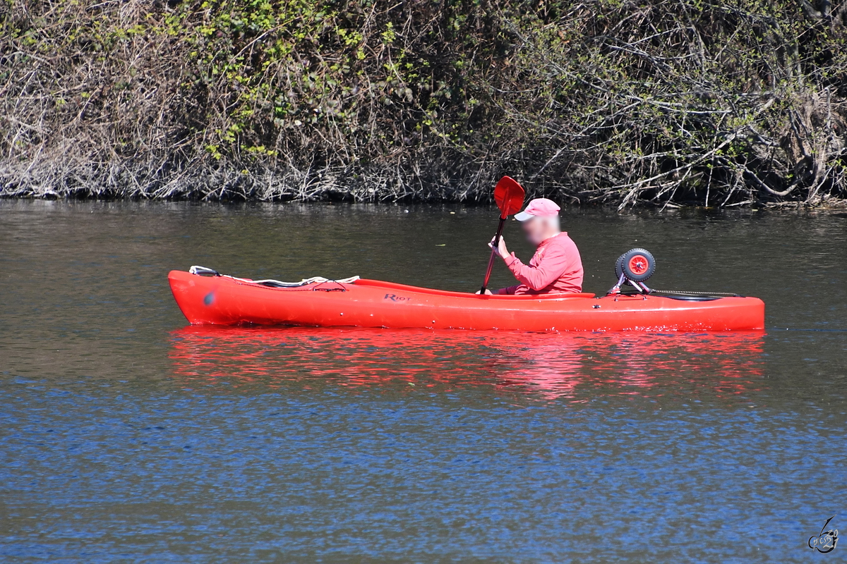 Unterwegs auf der Ruhr mit einem roten Paddelboot. (Witten, April 2021)