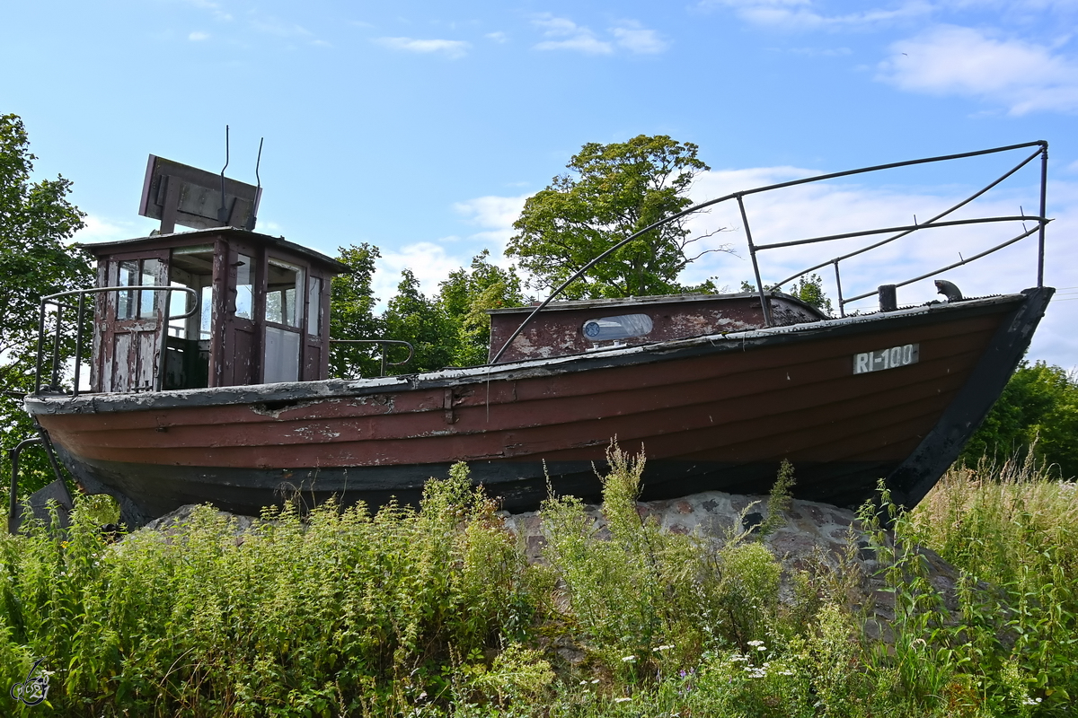 Wie eine Fata Morgana steht der ausgediente Fischkutter RI-100 INSEL RIEMS im satten Grün, so gesehen Mitte August 2021 in der Nähe von Greifswald.