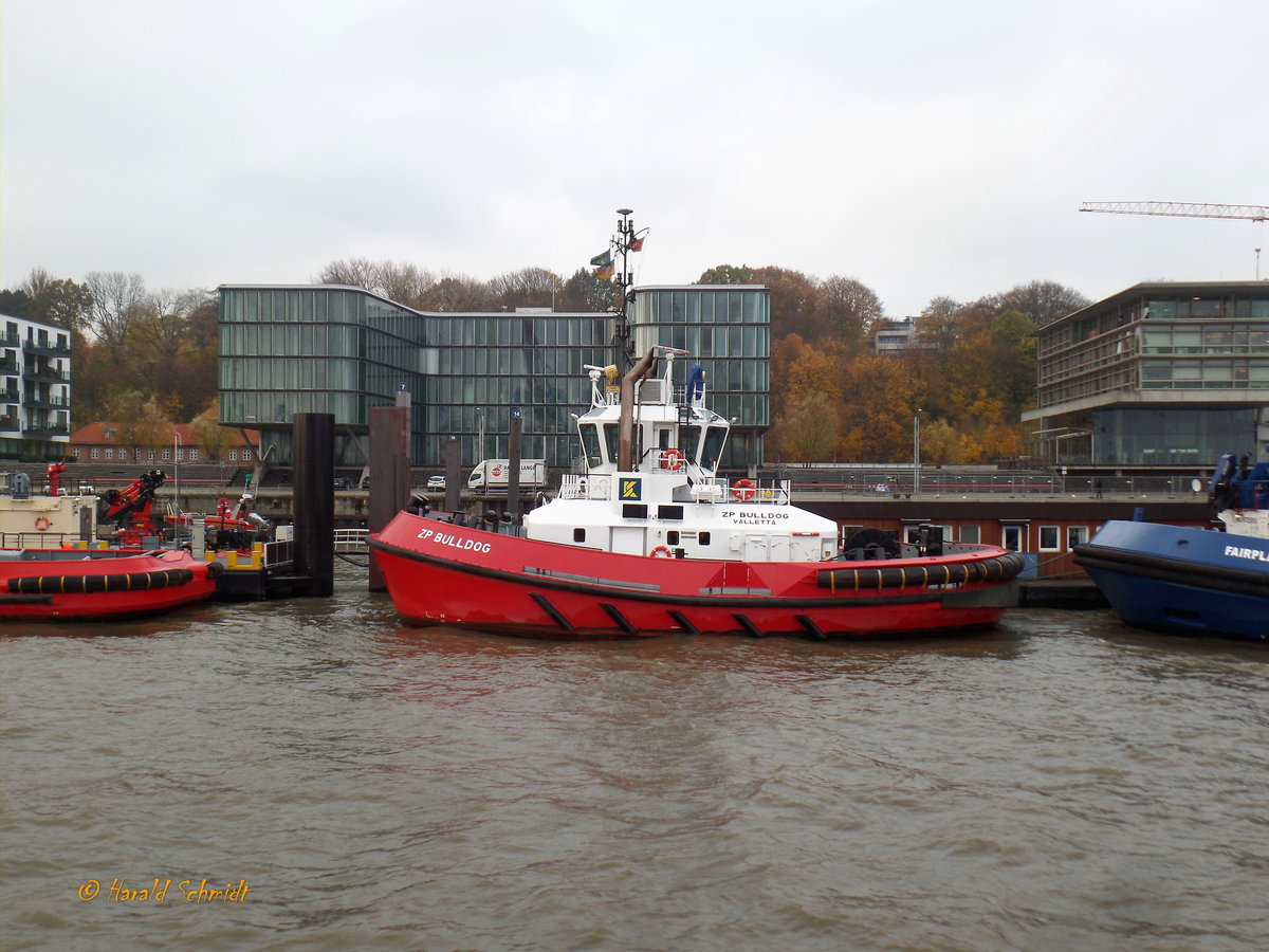 ZP BULLDOG (IMO 9597367) am 9.11.2018, Hamburg, Elbe, Schlepperponton Neumühlen   /

Schlepper / Damen ATD 2412 /  BRZ 299  / Lüa 24,74m, B 12,63 m, Tg 6,45 m / 2 Caterpillar-Diesel,  ges. 4200 kW, 5712 PS, 12 kn, Pfahlzug 70 t / 2012 gebaut / Manager: Kotug Smit Towage, Flagge: Malta, Heimathafen: Valetta /
