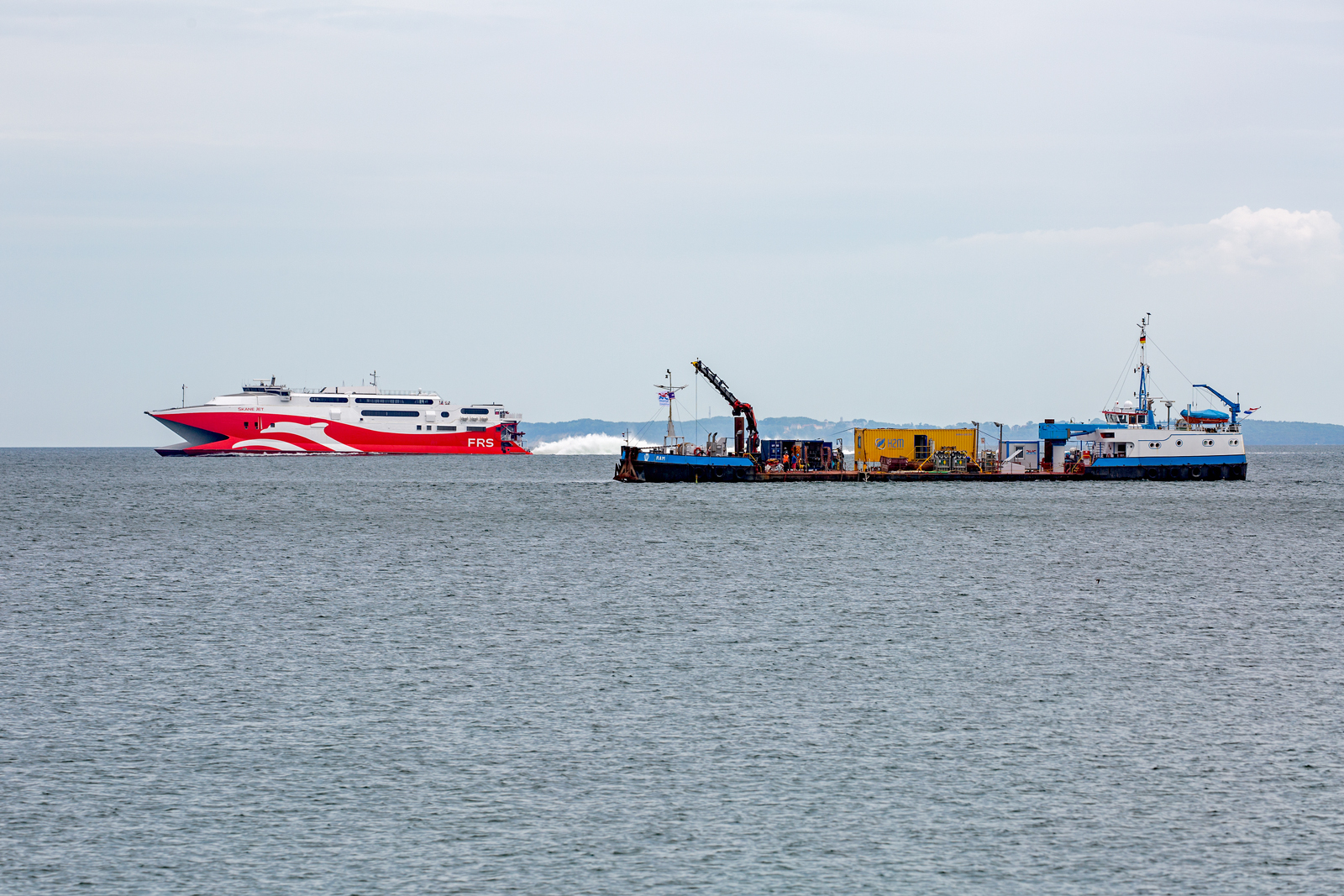 Arbeitsschiff RAM (IMO 8937259) z.Z. vor Sassnitz im Einsatz. Im Hintergrund  ist die SKANE JET der FRS zu sehen, die ab diesem Jahr wieder auf der alten Königslinie Mutkran-Trelleborg unterwegs ist. 24.06.2023