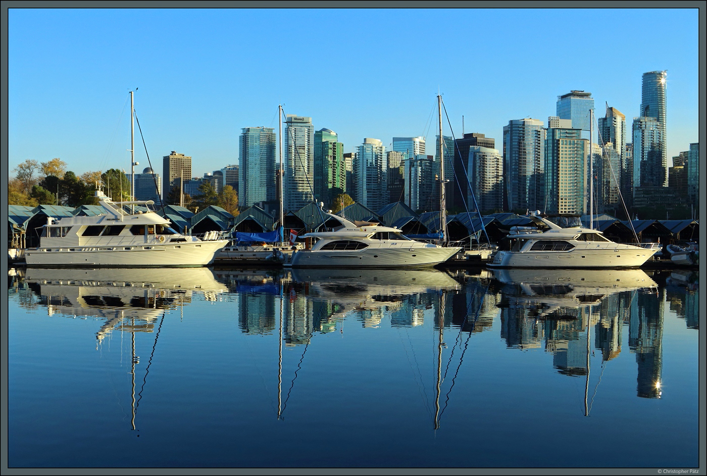 Mehrere Yachten spiegeln sich im Wasser des Coal Harbour vor der Kulisse der Downtown Vancouver. (15.10.2022)