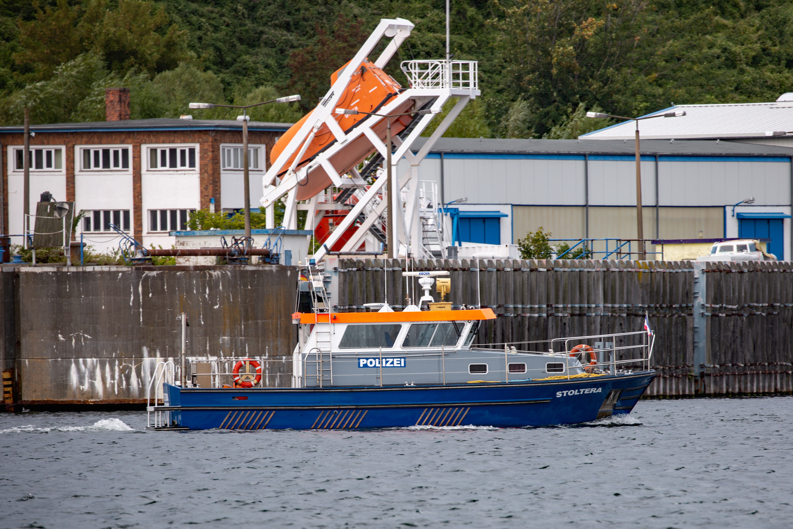 Polizeiboot STOLTERA der WSP im Sassnitzer Hafen. Im Hintergrund die dortige Übungsanlage für Schiffssicherheit. - 03.09.2023