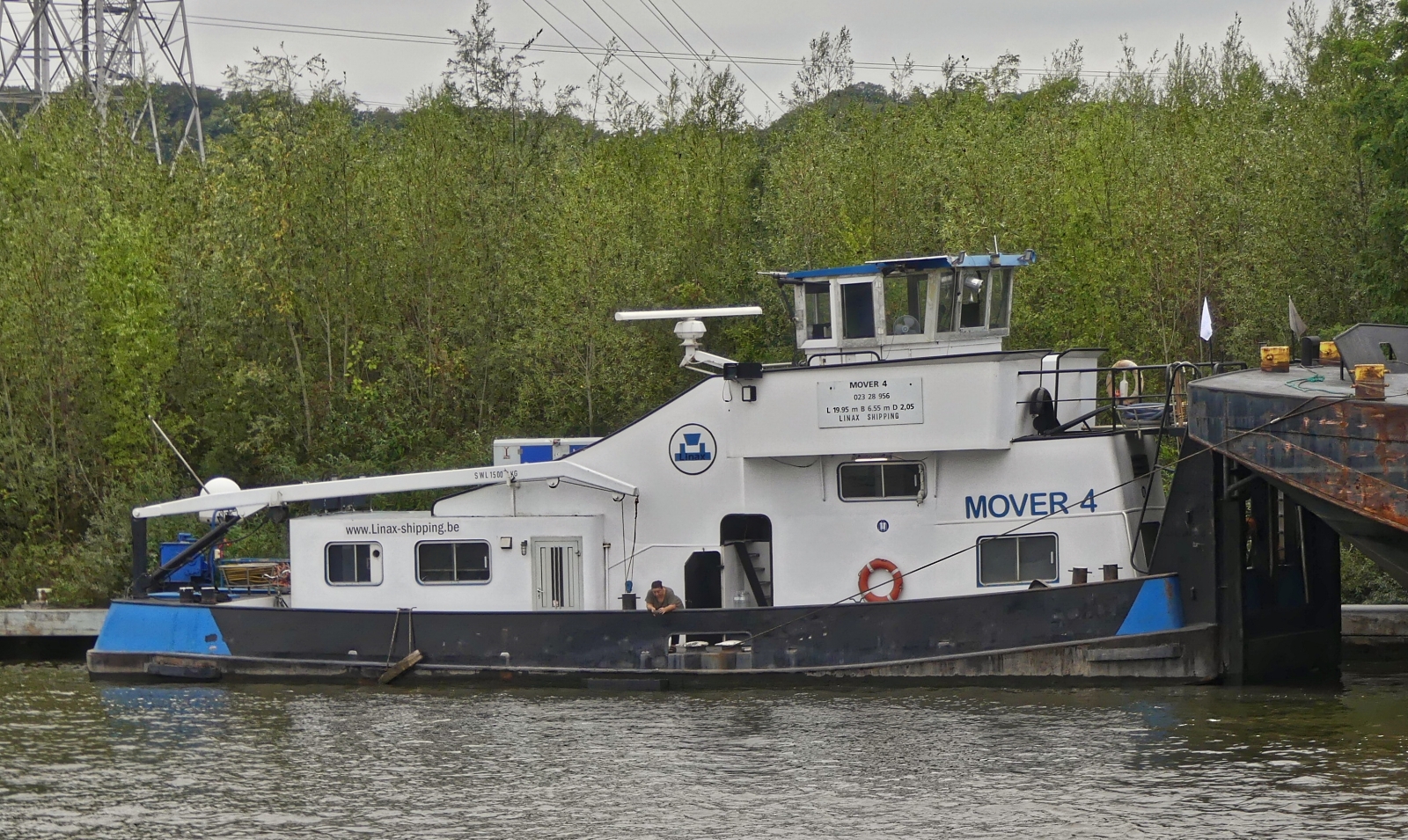 Schubboot MOVER 4; 023 28 956; L 19,95 m; B 6,55m; von Linax Shipping; mit einem Leichter gesehen am Ufer des Albertkanals an eine Verladestation. 09.2025 Gebaut 1957, unter dem Namen Willem-Matthijs, Regiena-Anneliese, Xanthos, Samila, Nicolette, Rubana, Birjo, BJ 1957, seit 2007 unter Mover 4 unterwegs, gemeldet in Ridderkerk