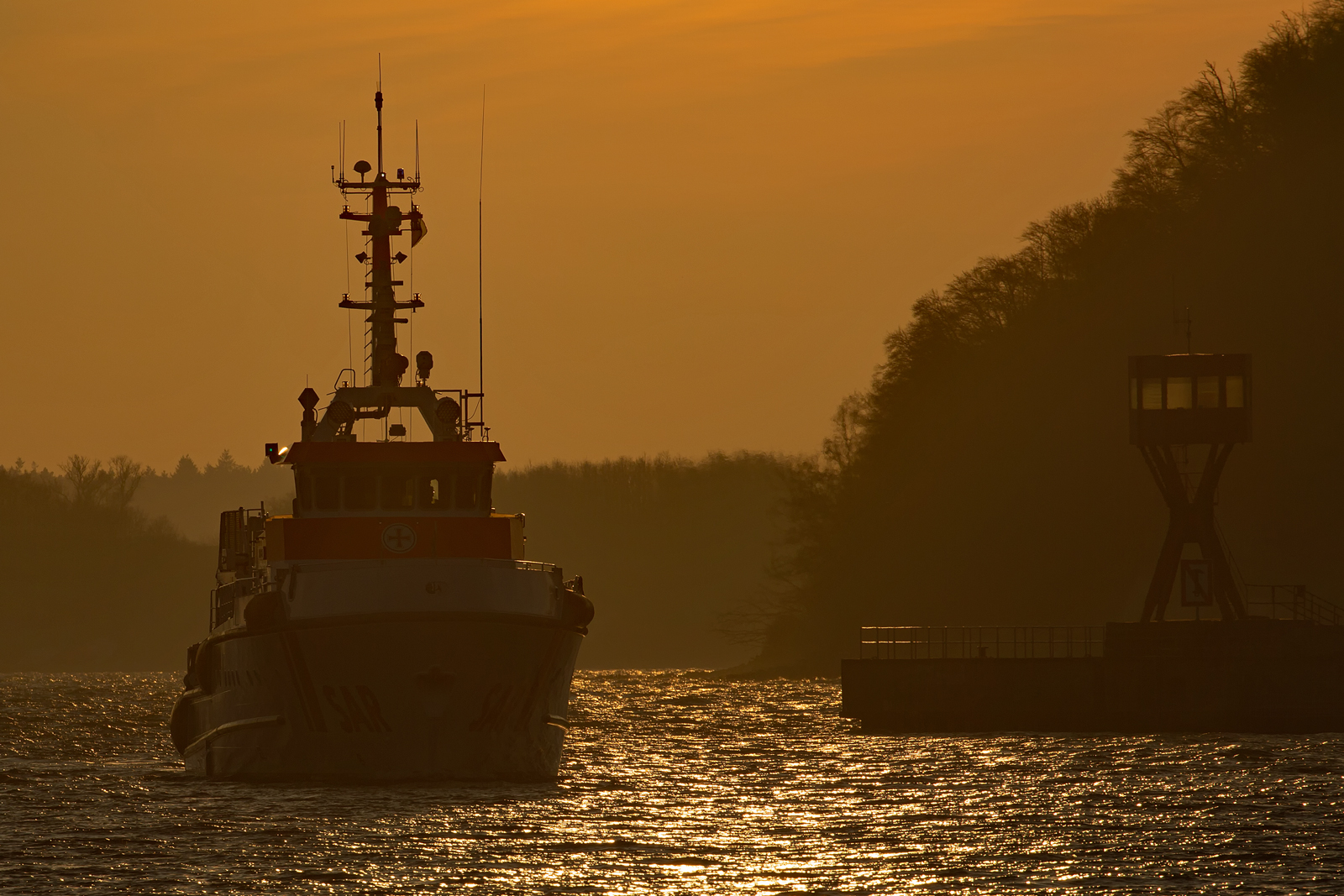 Seenotrettungskreuzer HARRO KOEBKE Höhe Sassnitzer Westmole bei Gegenlicht am frühen Abend. - 08.02.2023
