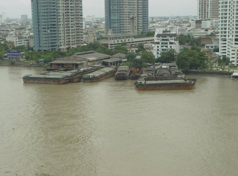 Am 07.07.2009 liegen im Chao Phraya Fluß in Bangkok diese antriebslosen Lastkähne und warten auf Aufträge, um dann von den kleinen leistungsstarken Schleppern zu ihren Auftragszielen gezogen zu werden