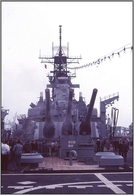 Blick auf den achteren Geschtzturm Y der USS Iowa, aufgenommen von dem Hubschrauber-Landedeck. Ein Hangar zur Unterbringung von Hubschraubern war nicht vorhanden. Auf der Steuerbord-Seite kann man einen Ladebaum fr die Versorgung mit Treibstoff erkennen. Zur weiteren Geschichte des Schiffes: Bereits 1990 wurde die USS Iowa wieder auer Dienst gestellt und erneut in die Reserve verlegt. Das letzte der reaktivierten Schwesterschiffe USS Wisconsin folgte ihr 1992 nach der Teilnahme am 2. Golfkrieg in die Reserve. Letztlich war der Unterhalt dieser alten Schiffe mit ihren rund 1500 Mann Besatzung zu teuer, auerdem war der Kalte Krieg mit dem Ostblock zu Ende. Inzwischen wurden die 4 Schlachschiffe auch aus der Schiffsliste der US-Navy gestrichen und werden z.T. bereits als Museumsschiffe verwendet. In der Wikipedia gibt es einen informativen Artikel ber die Iowa-Klasse. (Dia-Archiv Alfred Schmidt, September 1986 in Bremerhaven)  