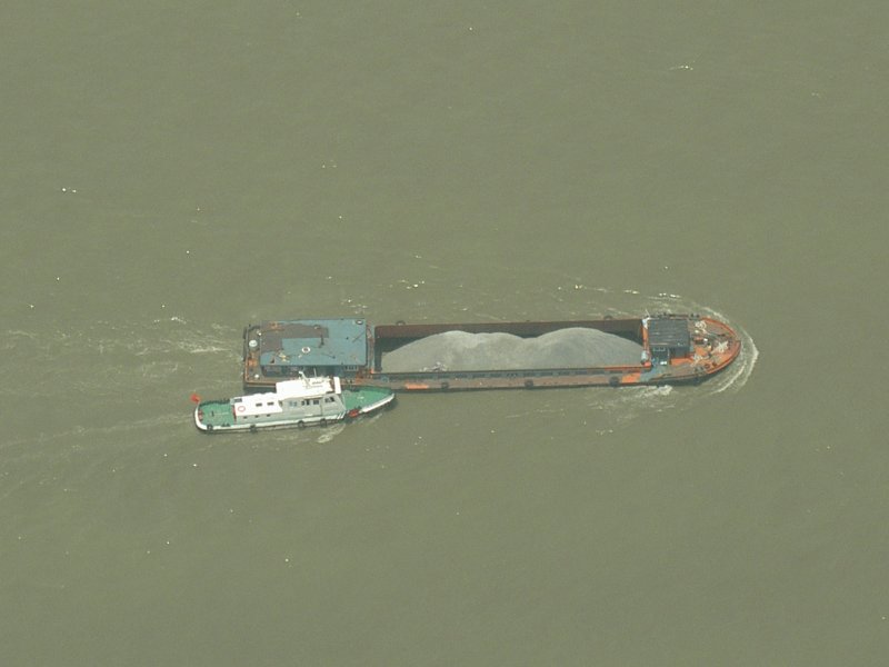 Blick vom Oriental tower auf den Huangpu Fluss am 20.05.2006.
Unten sieht es so aus, dass der Kiesfrachter von einem Polizeiboot aufgebracht wird.
