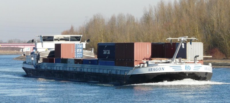 Das belgische Frachtschiff  Aragon  fhrt mit einer Ladung Container im Rhein-Seiten-Kanal zu Berg, oberhalb der Einfahrt zum Kanal nach Niffer. Datum: 03.02.2008. Heimathafen: Brugge, Europa-Nummer: 6004158. Mit einer Lnge 110 m und einer Breite von 11,45 m entspricht es den derzeitigen Standard-Schiffstyp auf dem Rhein. Die Tragfhigkeit dieses Schiffes liegt bei 3281 Tonnen. 