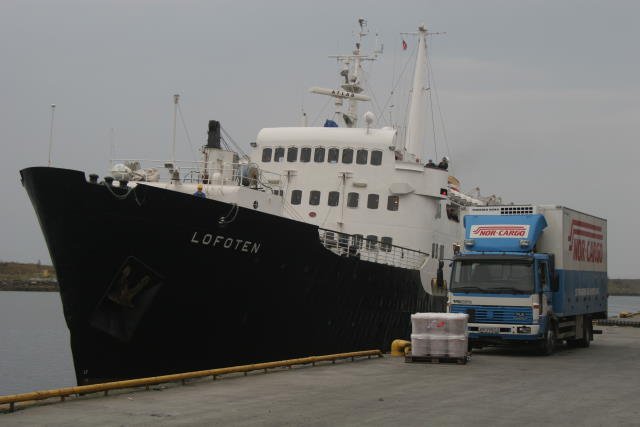 Die M/S  Lofoten  legt an den Hurtigrutenkai in Brnnsund an. Am Kai steht schon die erste bereitgestellte Ladung und ein NorCargo LKW zum Weitertransport der Ladung. Der Hafen ist einer der schnsten Hfen entlang der Kste; 18.09.2006, sdgehend