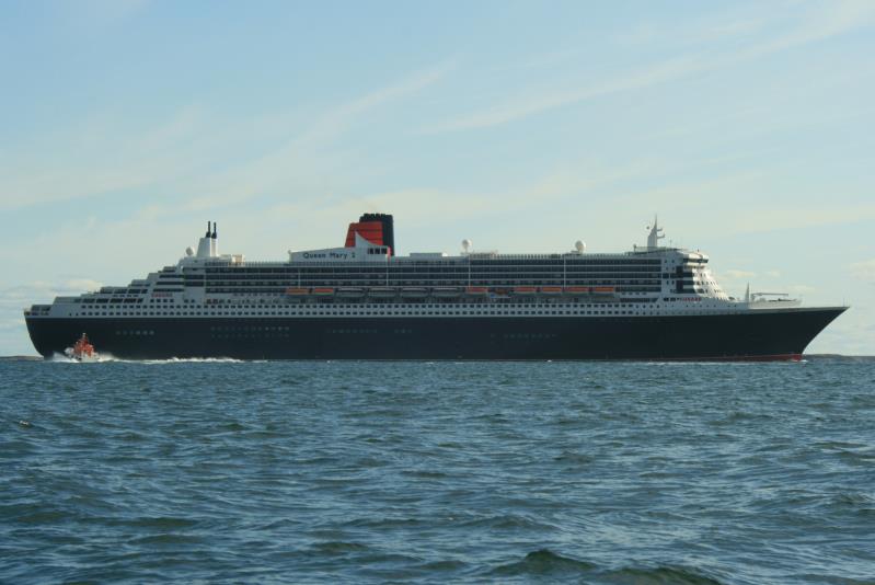 Die Queen Mary 2 zwei Fahrstunden nrdlich von Bergen am Ausgang des Hjeltefjorden. Kurz vor der Insel Fedje verlangsamt sie ihre Fahrt und setzt den Lotsen ab. Das Lotsenboot ist vor dem Heck zu sehen. Durch die geringe Geschwindigkeit konnten wir mit unserem Boot einige Minuten neben dem Ozeanriesen fahren. Fedje,10.06.2009