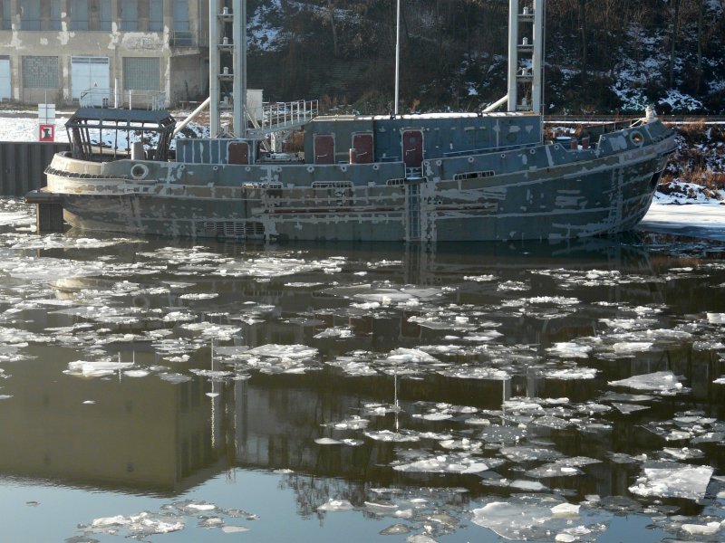 Dieser Kasko (Rohbau) lag am 22.01.2009 im Rosawitzer Hafen in Děčín. Am Schanzkleid ist ANTWERPEN 30 aufgeschweißt. Sicher wurde er auf einer tschechischen Werft gebaut. Der Rumpfform nach könnte es ein Hafenschlepper werden. Das Ruderhaus steht sicher nur für die Überführung so weit am Heck. Vielleicht gibt es hier mal Fotos von der Überführung oder später vom Einsatzort?