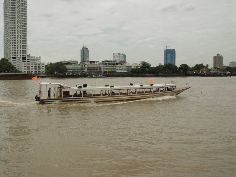 Dieses Express Boot auf dem Chao Phraya Flu in Bangkok bringt Fahrgste zu den verschiedenen am Flu liegenden Anlegestellen. Man kann hier erkennen, da der Schiffsfhrer im Bug des Bootes an einem groen Steuerrad sitzt, der Mann auf der hinteren Ein- und Ausstiegsplatform dirigiert den Schiffsfhrer beim An- und Ablegen lediglich mit Pfeifsignalen von einer Trillerpfeife (07.07.2009)