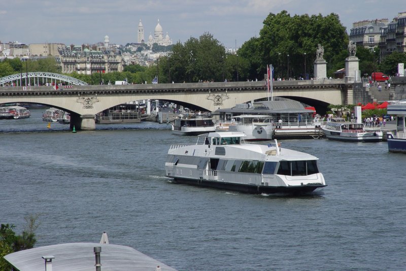 Dieses Rundfahrboot ist am 20.07.2009 vor der Kulisse von Sacre Coeur in Paris auf der Seine unterwegs