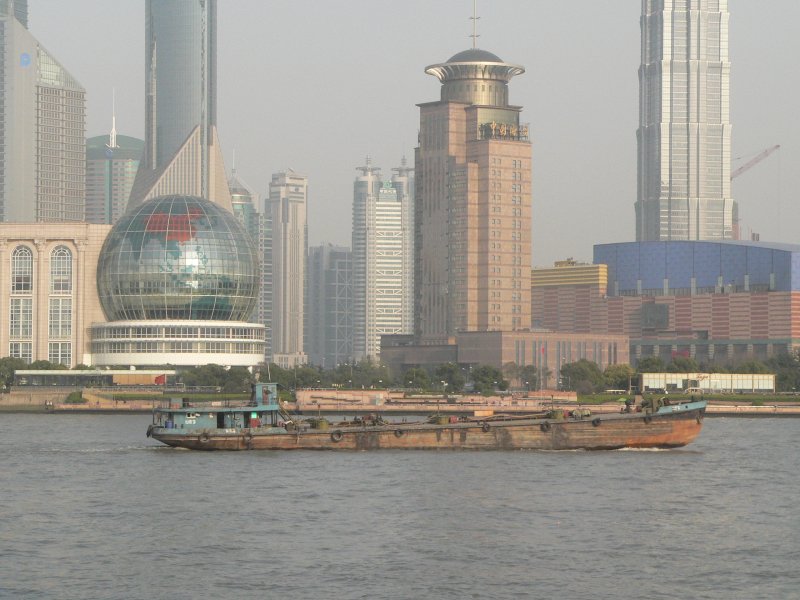 Einen interessanten Kontrast bildet dieses Transportschiff und im Hintergrund die moderne Huserkulisse von Shanghai. Fotografiert vom Bund aus, April 2006