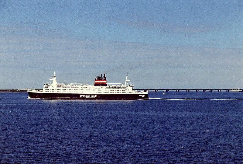 Eisenbahn-Fhre  Dronning Ingrid  fhrt am 05.08.1993 von Korsr nach Nyborg, aufgenommen von einer Gegenfhre. Im Hintergrund sieht man die 6,6 km lange westliche Balkenbrcke ber den Groen Belt, die 6,8 km lange stliche Hngebrcke war da noch im Bau, sie wurde im Sommer 1998 fr den Verkehr freigegeben, der Fhrverkehr wurde eingestellt.