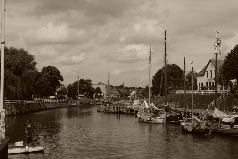 Ostfriesland in Schwarzweiss: Historische Schiffe in Carolinensiel im Einklang mit Himmel und Wolken