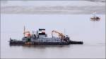 Der SPLER WESER wird am 20.07.2011 vom Schlepper HANSA (schaut hinter dem Bagger hervor) Weser aufwrts geschleppt.