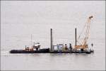 Der 1904 gebaute Schlepper WMME des Schleppbetriebs Unterweser (SBU) verbringt den Stelzenbagger HH 93 am 29.09.2008 auf der Weser.