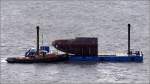 Der 1957 gebaute Schlepper WILGUM ist am 03.12.2011 mit einem Ponton auf der Weser in Richtung berseehfen in Bremerhaven unterwegs. Die Ladung besteht aus einem Wulstbug, der einem greren Schiff nachtrglich angeschweit werden soll.