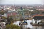 Spundwanderneuerung an der Geeste in Bremerhaven. Der Kran auf dem Arbeitsschiff BRAUNE hebt gerade ein Spundwandelement vom Transportponton CARRIER I, der vom Schubboot CECILIE an die Baustelle gebracht wurde. 06.11.2013
