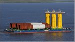 Der mit Turmsegmenten für Offshore-Windenergieanlagen beladene Ponton STRALSUND wird die Weser abwärts Richtung Nordsee gezogen. Der Ponton ist 90 m lang und 32 m breit und hat eine Tragfähigkeit von 12.000 t. 
Bremerhaven, 28.07.2016.