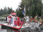 Viele lustige Gestallten auf einer selbstgebauten schwimmenden Kutsche.  Das Vehikel war Teilnehmer am Bootscorso anlässlich des 15.Brückenfest  in Schwaan auf der Warnow.