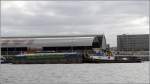 Das Schubboot MAASSTROOM 7 (ENI 02308423) schiebt am 09.06.2015 den Güterschubleichter ROLINDA (ENI 02335262) durch Amsterdam.
Die MAASSTROOM 7 wurde 1952 gebaut, ist 27,3 m lang und 6,3 m breit. Heimathafen ist Nederhemert (Niederlande).
Die ROLINDA wurde 2012 gebaut, ist 38,25 m lang, 7,4 m breit und hat eine Tonnage von 550 t. Heimathafen ist Utrecht (Niederlande).