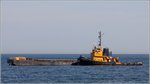 Der 1968 gebaute Schlepper SCHWARTENBEK (IMO 8865652) ist am 31.08.2016 mit der Klappschute HUBERTUS bei Helgoland unterwegs.
Die SCHWARTENBEK ist 27,18 m lang und 8,50 m breit und hat eine Maschinenleistung von 529 kw. Heimathafen ist Harlingen (Niederlande). Frühere Namen: CONRAD, PETER, WIELINGEN.
Die antriebslose Klappschute HUBERTUS wurde 1988 gebaut, ist 41,03 m lang und 8,54 m breit, die Tragfähigkeit beträgt 362 t. Heimathafen ist Brake.