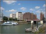 Der Duisburger Innenhafen am 04.08.2007. Im Hintergrund erkennbar die 1950 erbaute Schwanentorbrcke, ber die gerade eine Straenbahn fhrt.