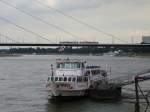 Das Passagierschiff   Heinrich Heine   legt in wenigen Minuten in Dsseldorf ab, whrend im Hintergrund die Straenbahn schon fhrt.