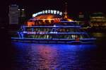 Ein Touristenschiff auf dem  Huangpu Jiang vor der Skyline von Pudong in Shanghai bei Nacht am 28.10.2014 beobachtet.